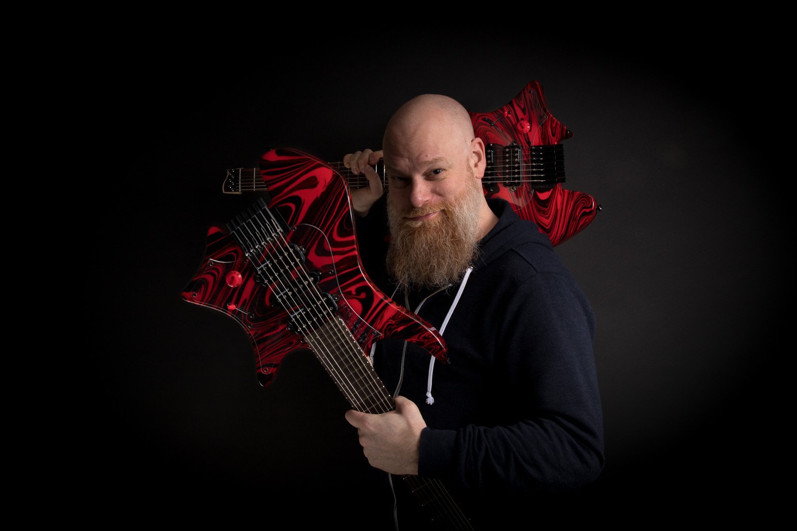 Per Nilsson holding Headless Guitar Boden Singularity 7-string Red Swirl