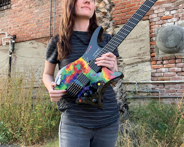 Sara Longfield posing with her signature headless guitar