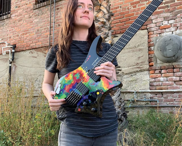 Sara Longfield posing with her signature headless guitar