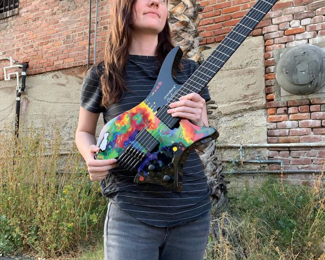 Sara Longfield posing with her signature headless guitar